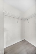 Walk-in closet featuring wire shelving, light wood-finish flooring, and white baseboards - 