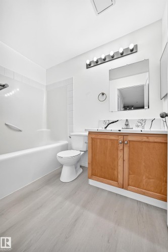 Bathroom featuring a light wood-finish vanity with a white countertop and integrated sink - #214 245 Edwards Dr Sw, Edmonton, AB - Indoor Photo Showing Bathroom