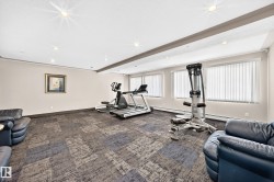 Spacious recreation room featuring recessed lighting and a drop ceiling with decorative beam - 