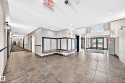Spacious lobby featuring large format tile flooring and an arched transom window above the entrance - 