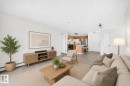 Open-concept living area featuring light wood-finish flooring, white baseboards, and neutral wall tones - #214 245 Edwards Dr Sw, Edmonton, AB  - Indoor Photo Showing Living Room 