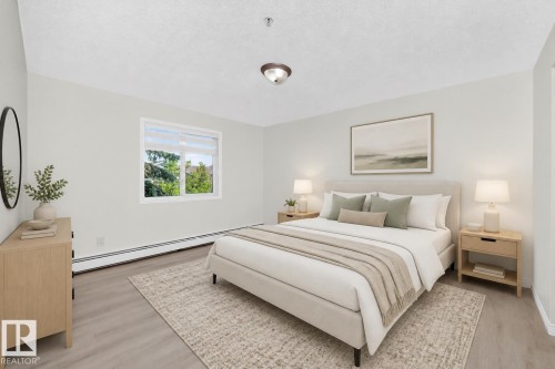 Spacious room featuring light wood-finish flooring, a contemporary window, and neutral wall tones - #214 245 Edwards Dr Sw, Edmonton, AB - Indoor Photo Showing Bedroom