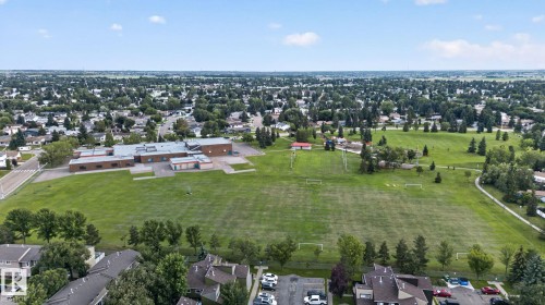 Expansive green space featuring large athletic fields, a paved walking path, and mature trees - 8146 27 Avenue Nw, Edmonton, AB - Outdoor With View