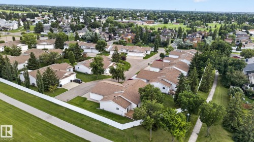 Residential community featuring single-story homes with attached garages, surrounded by mature trees and manicured green spaces - 8146 27 Avenue Nw, Edmonton, AB - Outdoor With View