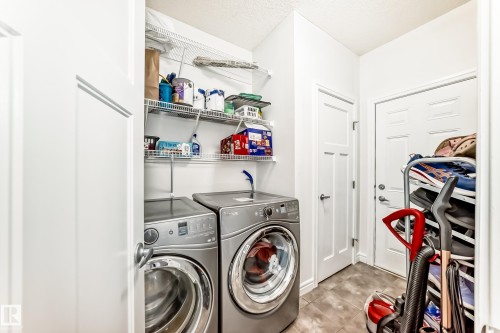 Laundry area featuring tile flooring, white panel doors, and wire shelving - 2812 12 Street Nw, Edmonton, AB - Indoor Photo Showing Laundry Room