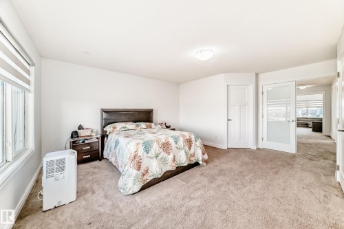 Spacious room featuring neutral carpet flooring, white walls, and a contemporary ceiling light fixture - 2812 12 Street Nw, Edmonton, AB - Indoor Photo Showing Bedroom