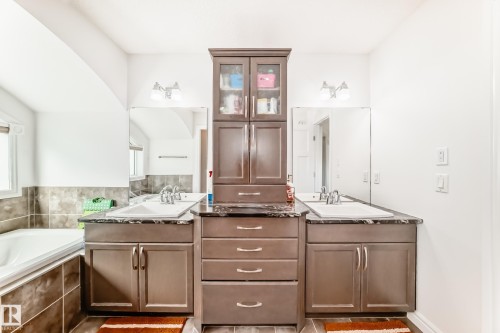 Double vanity featuring dark wood-finish cabinetry, integrated sinks, and polished countertops - 2812 12 Street Nw, Edmonton, AB - Indoor Photo Showing Bathroom