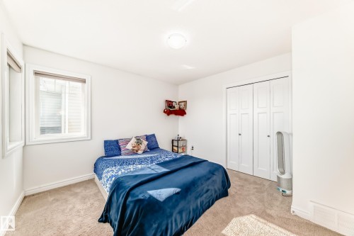 Carpeted room featuring white walls, a single window with blinds, and white bi-fold closet doors - 2812 12 Street Nw, Edmonton, AB - Indoor Photo Showing Bedroom