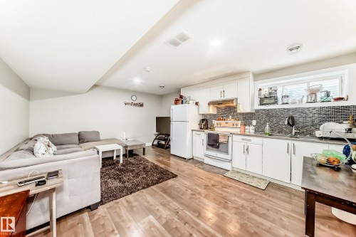 Open-concept living space featuring wood-finish flooring, recessed lighting, and a kitchen with white cabinetry - 2812 12 Street Nw, Edmonton, AB - Indoor
