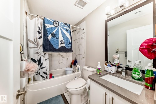 Bathroom featuring a white vanity with a gray countertop, an integrated rectangular sink, and a framed mirror - 2812 12 Street Nw, Edmonton, AB - Indoor Photo Showing Bathroom