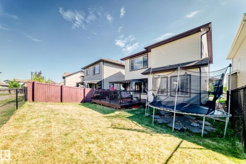 Expansive backyard featuring a fenced perimeter, a wooden deck, and a two-story residence with light-colored siding - 2812 12 Street Nw, Edmonton, AB - Outdoor With Deck Patio Veranda