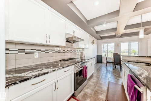 Kitchen with white cabinetry, stainless steel appliances, and dark patterned countertops - 2812 12 Street Nw, Edmonton, AB - Indoor Photo Showing Kitchen With Upgraded Kitchen