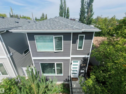 Modern exterior with dark gray horizontal siding, white trim, and a gabled roof - 15212 98 Avenue Nw, Edmonton, AB - Outdoor