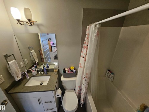 Vanity with integrated sink, stone-finish countertop, and white cabinetry - 15212 98 Avenue Nw, Edmonton, AB - Indoor Photo Showing Bathroom