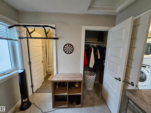 Window with blinds, wall-to-wall carpeting, wood-finish shelving unit, paneled doors, and ceiling with tray detail - 15212 98 Avenue Nw, Edmonton, AB - Indoor