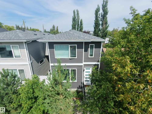 Contemporary two-story exterior with gray siding, white window trim, and a gray shingle roof - 15212 98 Avenue Nw, Edmonton, AB - Outdoor