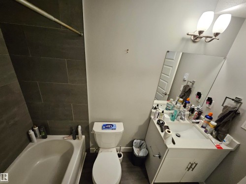 Full bathroom with a white tub, dark tile shower surround, and a white vanity with a single sink - 15212 98 Avenue Nw, Edmonton, AB - Indoor Photo Showing Bathroom