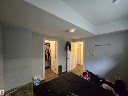 Recessed ceiling, neutral wall paint, wood-finish flooring, paneled interior doors, and overhead lighting - 15212 98 Avenue Nw, Edmonton, AB - Indoor Photo Showing Other Room