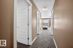 Hallway with textured carpeting and recessed lighting - 