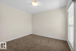 Neutral-toned walls, textured ceiling, flush mount lighting, brown carpeting, and a window with blinds - 