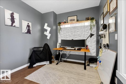Modern home office featuring gray walls, wood-finish flooring, and a geometric area rug - 3936 Claxton Loop Sw, Edmonton, AB - Indoor Photo Showing Office