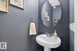 Pedestal sink with polished chrome faucet, oval mirror, and wall-mounted towel ring - 