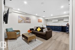 Finished basement recreation room featuring plank wood-finish flooring, recessed ceiling lighting, and wall-mounted flat-screen television - 