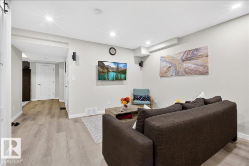 Recessed lighting illuminates the open-concept living space, featuring light wood-finish flooring and neutral wall tones - 3936 Claxton Loop Sw, Edmonton, AB - Indoor