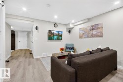 Recessed lighting illuminates the open-concept living space, featuring light wood-finish flooring and neutral wall tones - 