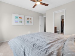 Recessed lighting, wood-finish ceiling fan, neutral wall paint, carpeted flooring, and a white interior door - 