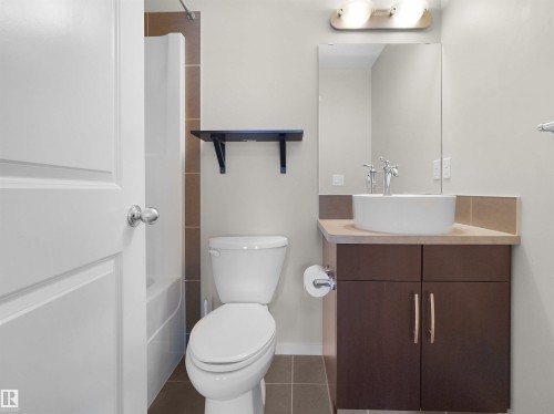 Vessel sink with chrome faucet, dark wood-finish vanity, and tiled floors - #89 603 Watt Bv Sw, Edmonton, AB - Indoor Photo Showing Bathroom