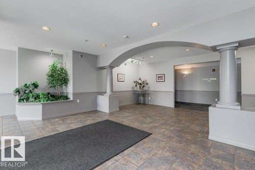 Welcoming lobby featuring polished tile flooring, recessed ceiling lighting, and curved architectural archway - #208 10421 42 Av Nw, Edmonton, AB - Indoor Photo Showing Other Room