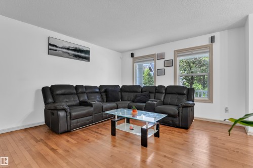 Bright living area featuring wood-finish flooring and white walls - 7223 19A Avenue Sw, Edmonton, AB - Indoor Photo Showing Living Room