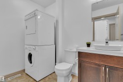 Compact bathroom featuring a contemporary wood-finish vanity with a vessel sink, a wall-mounted mirror, and a white toilet - 