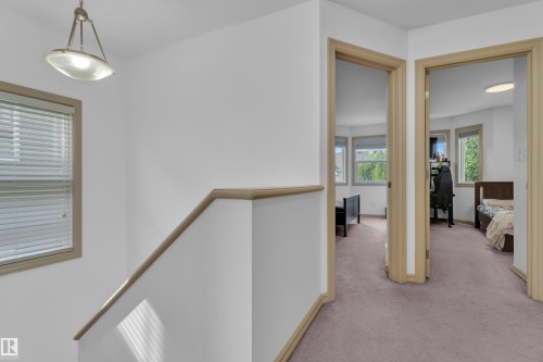 Upper-level hallway featuring light wood-finish trim, white walls, and neutral carpet flooring - 7223 19A Avenue Sw, Edmonton, AB - Indoor Photo Showing Other Room