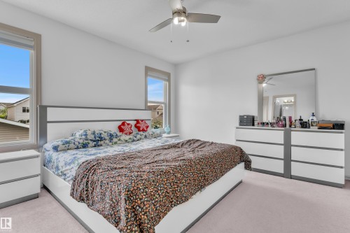Spacious bedroom featuring light-colored carpeting and white walls - 7223 19A Avenue Sw, Edmonton, AB - Indoor Photo Showing Bedroom