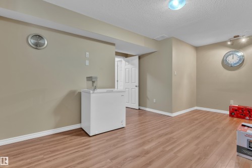 Finished room featuring wood-finish flooring, neutral wall paint, and white baseboards - 7223 19A Avenue Sw, Edmonton, AB - Indoor Photo Showing Other Room