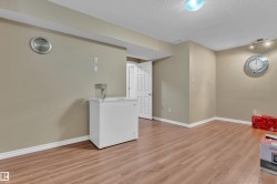 Finished room featuring wood-finish flooring, neutral wall paint, and white baseboards - 
