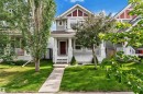Modern façade featuring grey siding with red trim accents, a welcoming front porch with white railings, a contrasting red front door, and a manicured lawn with established trees - 7223 19A Avenue Sw, Edmonton, AB  - Outdoor With Facade 