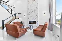 Two-story living area featuring a prominent marble-look fireplace surround with an integrated electric fireplace - 