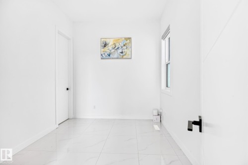 Bright room featuring large format tile flooring, white walls, and a single window - 3926 41 Avenue, Beaumont, AB - Indoor Photo Showing Other Room