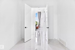 White walls and large format tile flooring complement contemporary doors with matte black hardware - 