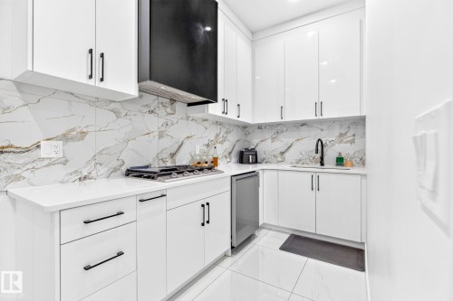 Kitchen featuring white cabinetry with black hardware, white countertops, a gas cooktop, and a black range hood - 3926 41 Avenue, Beaumont, AB - Indoor Photo Showing Kitchen With Upgraded Kitchen
