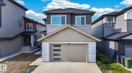 Contemporary two-story residence featuring a two-tone facade, an attached single-car garage with modern frosted glass inserts, and a concrete driveway - 3926 41 Avenue, Beaumont, AB - Outdoor