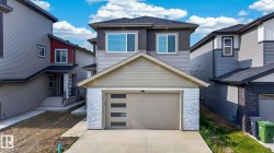 Contemporary two-story residence featuring a two-tone facade, an attached single-car garage with modern frosted glass inserts, and a concrete driveway - 