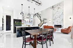Spacious interior featuring high ceilings, white tile flooring, and a large kitchen island with pendant lighting - 
