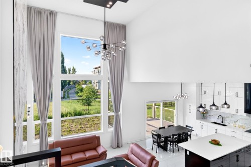 Two-story living area with expansive window wall, high ceilings, and contemporary lighting fixtures - 3926 41 Avenue, Beaumont, AB - Indoor