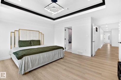 Light wood-finish flooring complements the white walls and trim - 3926 41 Avenue, Beaumont, AB - Indoor Photo Showing Bedroom