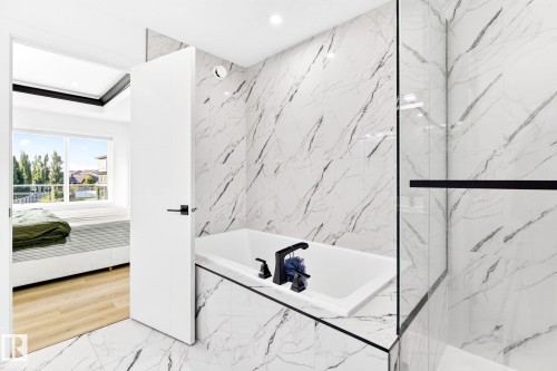 Bathroom featuring a built-in soaking tub with matte black fixtures, marble-patterned tile flooring and wall surround, and a glass shower enclosure with a black frame - 3926 41 Avenue, Beaumont, AB - Indoor Photo Showing Bathroom