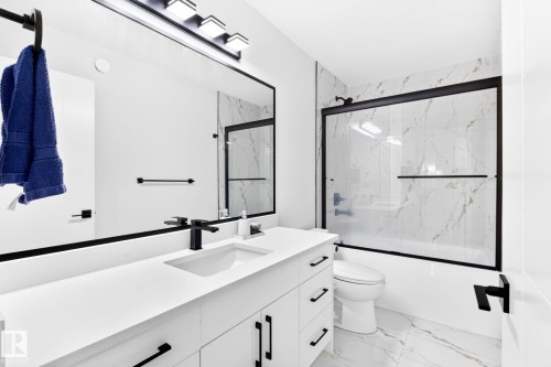 Bathroom featuring a single vanity with a white countertop, under-mount sink, and matte black faucet - 3926 41 Avenue, Beaumont, AB - Indoor Photo Showing Bathroom